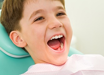 Young boy smiling in a dental chair. 