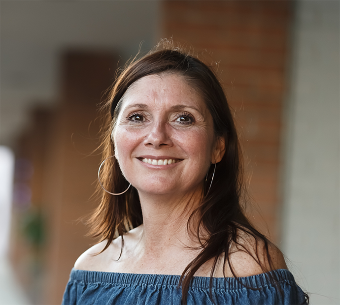 Smiling woman with long hair and hoop earrings