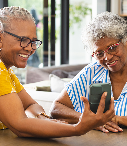 Woman showing another woman her cell phone