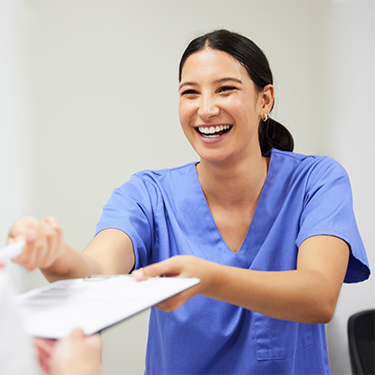 Female dental team member taking clipboard