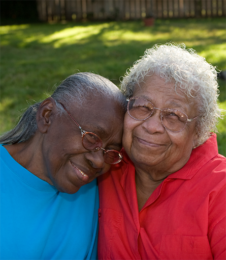 Close up of two senior women hugging outside
