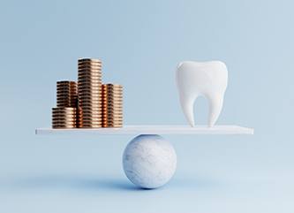 A balance beam holding gold coins and a giant false tooth