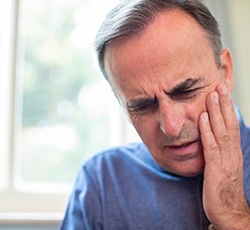 A man suffering from a dental emergency