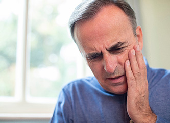 Pained man needs to visit his Dix Hills emergency dentist 