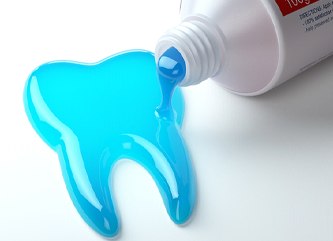 Fluoride toothpaste coming out of the tube in the shape of a tooth