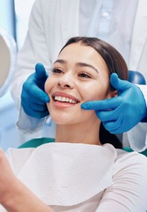 a patient smiling after improving her teeth