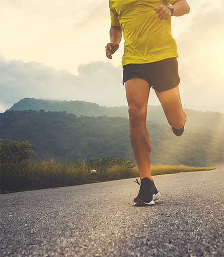 Person in yellow shirt jogging down a path
