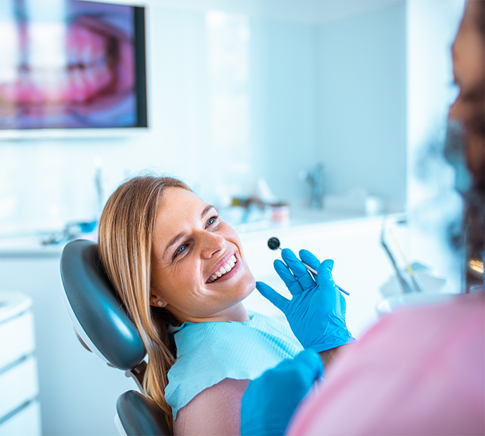 Female patient smiling up at dentist