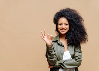 person holding up their hand and smiling