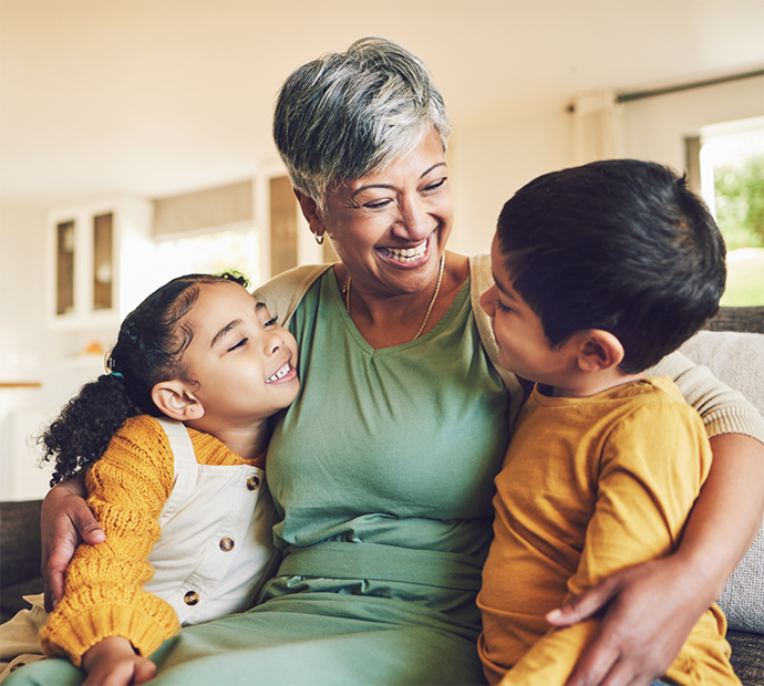 Older woman hugging two children on couch