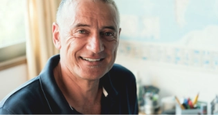 Close up of man in front of window smiling