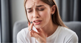 Woman with jaw pain touching her cheek