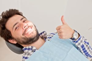 man reclining in dental chair smiling