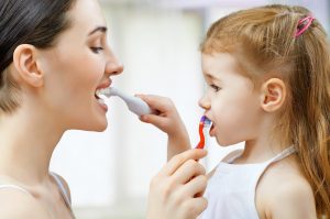 A mother and daughter brushing their teeth 