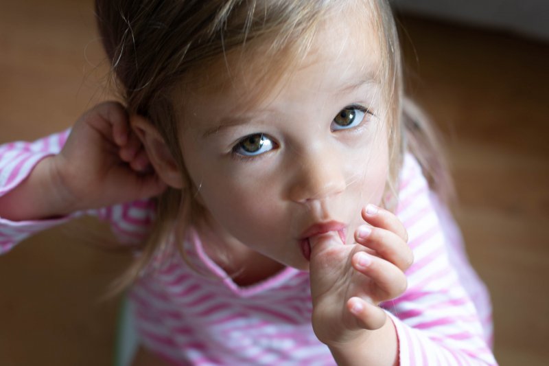 a little girl sucking her thumb before seeing a pediatric dentist in Huntington