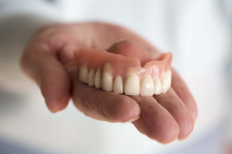 person holding denture 