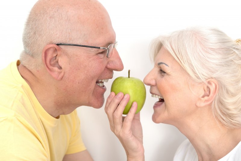 Couple with dentures about to bite into an apple