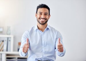 Man smiling and holding thumbs up