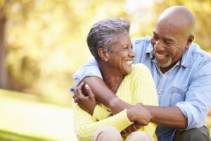 Older couple embracing and smiling.